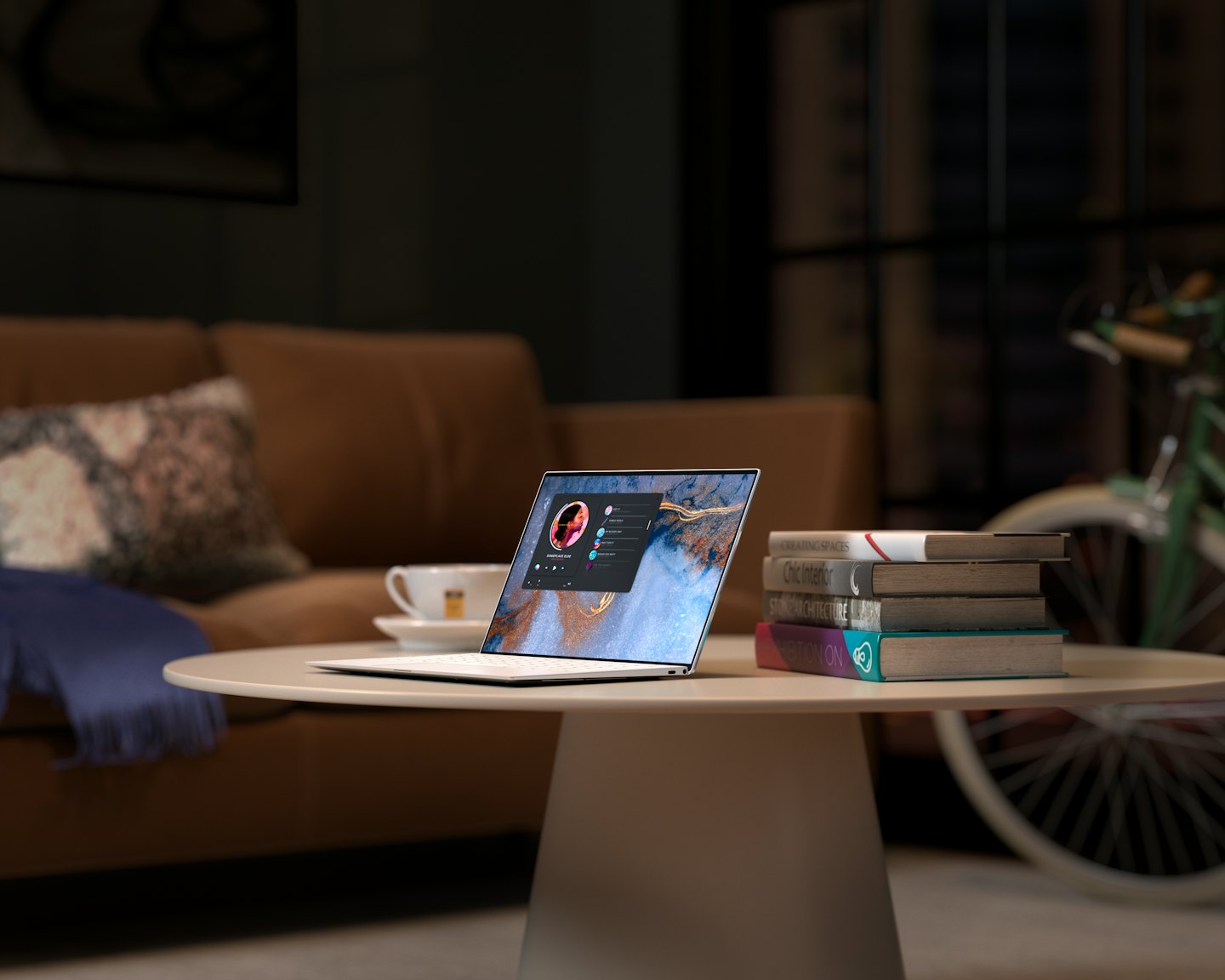 Portátil sobre una mesa de centro con libros y una manta.